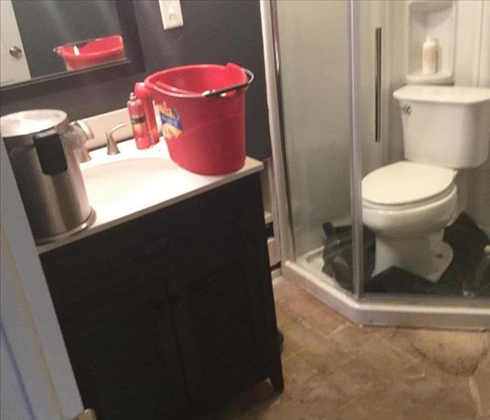 Dirty basement bathroom with water on the floor