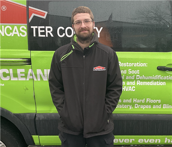 Travis standing in front of Servpro Van